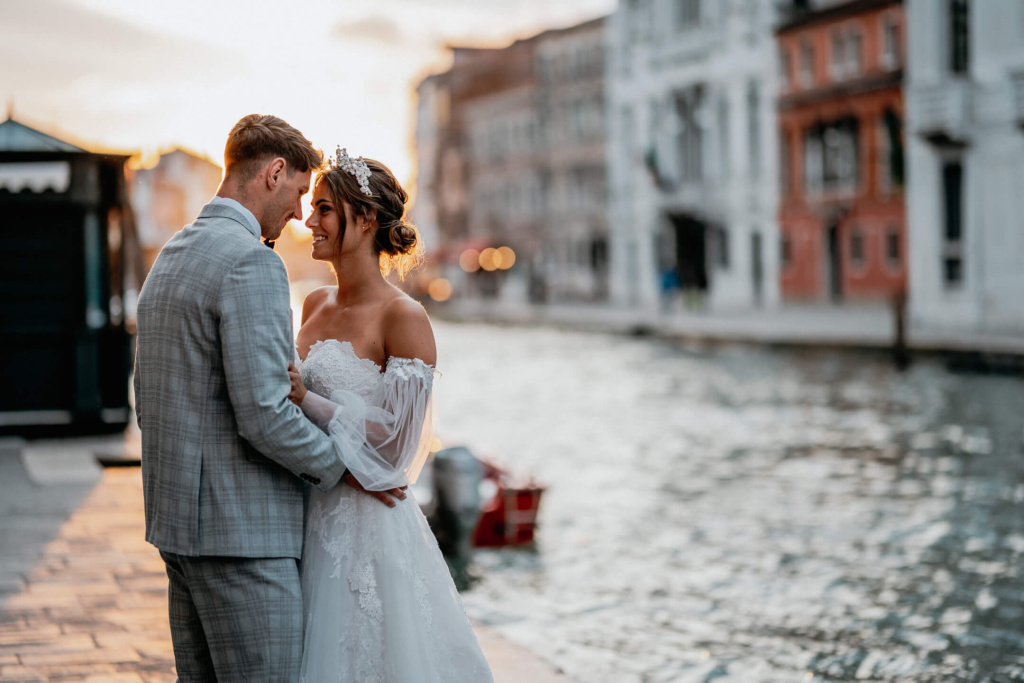 Brautpaar teilt einen romantischen Moment am Kanal in Venedig während der goldenen Stunde.